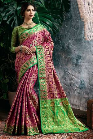 Celebrate This Festive With Beauty And Comfort Wearing This Designer Heavy Weaved Saree In Magenta Pink Color Paired With Contrasting Green Colored Blouse. This Saree And Blouse Are Fabricated On Art Silk Beautified With Weave All Over. 