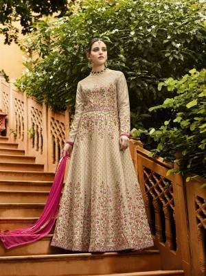 Simple And Elegant Looking Designer Floor Length Suit Is Here In Beige Color Paired With Dark Pink Colored Dupatta. Its Heavy Embroidered Top Is Fabricated On Art Silk Paired With Santoon Bottom And Chiffon Fabricated Dupatta. It Is Beautified With Attractive Thread And Jari Embroidery. 