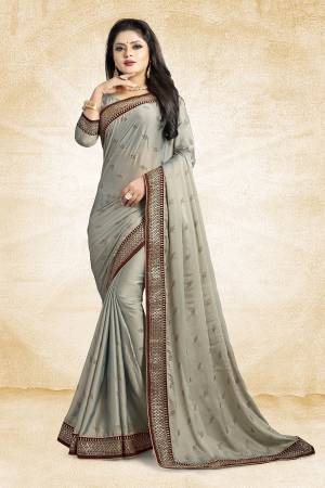 Flaunt Your Rich And Elegant Taste Wearing This Designer Saree In Grey Color Paired With Grey Colored Blouse. This Saree Is Fabricated On Satin Georgette Paired With Art Silk Fabricated Blouse. It Is Beautified With Heavy Embroidered Lace Border And Stone Work Butti Pattern Over The Saree. 