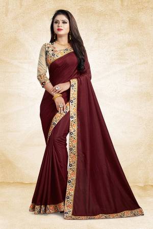 Here Is An Elegant And Royal Looking Designer Saree In Maroon Color Paired With Beige Colored Blouse. This Saree And Blouse Are Silk Based Based Beautified With Contrasting Thread Work Over The Blouse And Saree Lace Border. 
