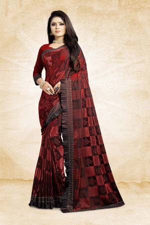Catch All The Limelight Wearing This Designer Saree In Maroon Color Paired With Maroon Colored Blouse. This Saree Is Fancy Fabric Based Paired With Art Silk Fabricated Blouse. It Is Beautified With Frill And Stone Work Over The Saree Border. 