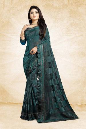 Catch All The Limelight Wearing This Designer Saree In Teal Green Color Paired With Teal Green Colored Blouse. This Saree Is Fancy Fabric Based Paired With Art Silk Fabricated Blouse. It Is Beautified With Frill And Stone Work Over The Saree Border. 