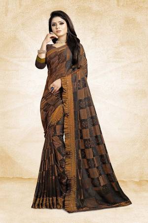 Catch All The Limelight Wearing This Designer Saree In Brown Color Paired With Brown Colored Blouse. This Saree Is Fancy Fabric Based Paired With Art Silk Fabricated Blouse. It Is Beautified With Frill And Stone Work Over The Saree Border. 