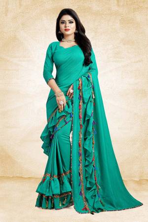 Catch All The Limelight At The Next Wedding You Attend With This Designer Saree In Sea Green Color Paired With Sea Green Colored Blouse. This Saree And Blouse are Silk Based Beautified With Fancy Laces And Frill Border. 