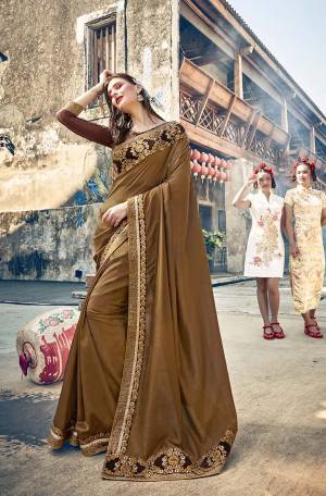 Flaunt Your Rich And Elegant Taste Wearing This Designer Saree In Dark Beige Color paired With Brown Colored Blouse. This Silk Based Rich Saree Is Paired With Art Silk And Net Fabricated Blouse. It Is Beautified With Heavy Embroidery. 