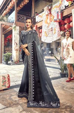 Flaunt Your Rich And Elegant Taste Wearing This Designer Saree In Grey And Black Color paired With Black Colored Blouse. This Silk Based Rich Saree Is Paired With Art Silk And Net Fabricated Blouse. It Is Beautified With Heavy Embroidery. 