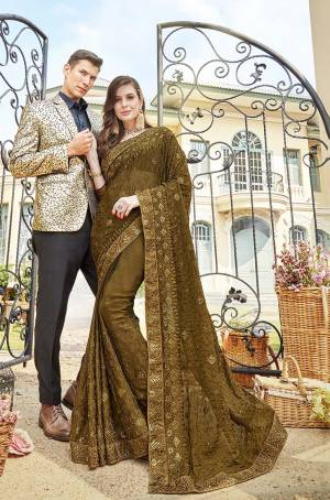 Grab This Very Pretty Designer Saree In Olive Green Color Paired With Olive Green Colored Blouse. This Heavy Embroidered Saree IS Fabricated On Chiffon Paired With Art Silk Fabricated Blouse. It Is Beautified With Rich And Subtle Tone To Tone Embroidery With Stone Work. Buy Now.