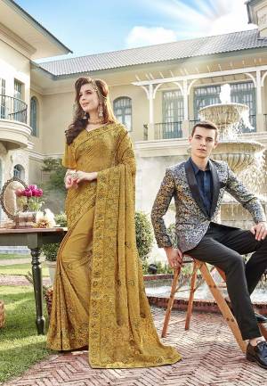 You Will Definitely Earn Lots Of Compliments In This Rich Looking Heavy Designer Saree In Golden Color Paired With Golden Colored Blouse. This Saree Is Chiffon Based Paired With Art Silk Fabricated Blouse. It Has Very Pretty Tone To Tone Embroidery All Over. 