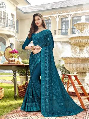 You Will Definitely Earn Lots Of Compliments In This Rich Looking Heavy Designer Saree In Teal Blue Color Paired With Teal Blue Colored Blouse. This Saree Is Chiffon Based Paired With Art Silk Fabricated Blouse. It Has Very Pretty Tone To Tone Embroidery All Over. 