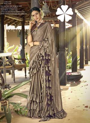 Here Is A Trending Frill Pattern Designer Saree In Sand Grey Color Paired With Brown Colored Blouse. This Saree Is Fabricated On Lycra Paired With Art Silk Fabricated Blouse. It Is Beautified With Frill And Lace Border. 