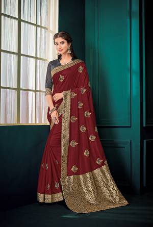 Here Is A Must Have Silk Based Designer Saree In Maroon Color Paired With Contrasting Dark Grey Colored Blouse. This Saree Is Fabricated On Art Silk And Jacquard Silk Pallu Paired With Art Silk Fabricated Blouse. It Is Beautified With Embroidered Butti All Over It.