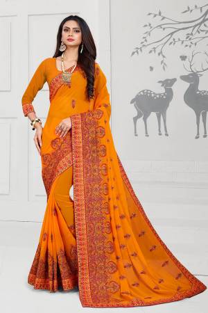 Get Ready For The Upcoming Festive And Wedding Season With This Heavy Deisgner Saree In Orange Color Paired With Orange Colored Blouse. This Saree And Blouse Are Fabricated On Georgette Beautified With Heavy Resham And Stone Work With Contrasting Thread Colors.