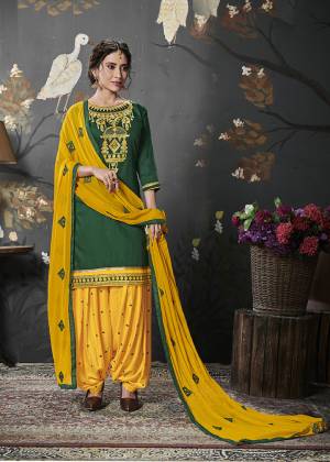 Celebrate This Festive Season With Beauty And Comfort With This Ethnic Color Pallete In Dark Green Colored Top Paired With Contrasting Musturd Yellow Colored Bottom And Dupatta. Its Heavy Embroidered Top Is Fabricated On Cotton Silk Paired With Rayon Bottom And Chiffon Fabricated Dupatta. 