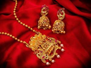 Give An Enhanced Look To Your Personality By Pairing Up This Beautiful Pendant Set With Your Ethnic Attire. This Pretty Set Is In Golden Color Beautified With Multi Colored Stone And Pearl Work. Buy Now.