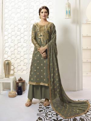 Add This New Shade To Your Wardrobe With This Designer Straight Suit In Olive Green Color Paired With Olive Green Colored Bottom And Dupatta. Its Top Is Fabricated On Banarasi Silk Paired With Santoon Bottom And Chiffon Fabricated Dupatta. It Is Beautified With Attractive Golden Weave And Lace Border.