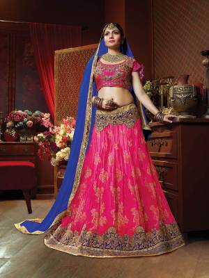 Add This Beautiful Heavy Designer Lehenga Choli For The Upcoming Wedding Season In Rani Pink Colored Blouse Paired With Contrasting Royal Blue Colored Dupatta. Its Blouse Is Fabricated On Art Silk Paired With Jacquard Net Fabricated Lehenga And Chiffon Fabricated Dupatta. 