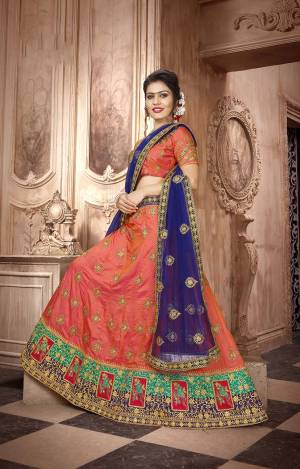 Bright And Visually Appealig Color Pallete Is Here With This Designer Lehenga Choli In Orange Color Paired With Contrasting Royal Blue Colored Dupatta. This Lehenga Choli IS Silk Based Paired With Net Fabricated Dupatta. Buy Now.