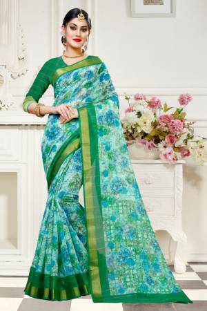 For Your Work Place And Comfort, Grab This Printed Saree In Sky Blue Color Paired With Green Colored Blouse. This Saree And Blouse are Fabricated On Cotton Silk Beautified With Floral Prints All Over It. Buy This Saree Now.
