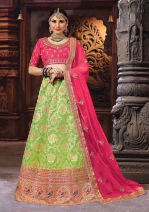 Add This Very Pretty And Colorful Designer Lehenga Choli In Dark Pink Colored Blouse And Dupatta Paired With Contrasting Light Green Colored Lehenga, Its Blouse Is Fabricated On Art Silk Paired With Banarasi Jacquard Silk Lehenga And Net Fabricated Dupatta.  It Is Beautified With WEave And Embroidery Making It More Attractive. 