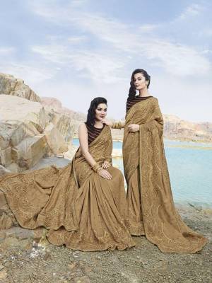 Flaunt Your Rich And elegant Taste Wearing This Designer Saree In Beige Color Paired With Contrasting Brown Colored Blouse. This Saree Is Fabricated on Soft Silk Beautified With Lovely Tone To Tone Embroidery And Pearl Work. Its Rich Fabric And Color Gives An Elegant And Subtle Look Which Will Earn You Lots Of Compliments From onlookers. 
