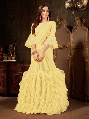 Add This Beautiful Designer Ruffled Saree To Your Wardrobe In Yellow Color For The Upcoming Festive And Wedding Season. This Trendy Saree Is Fabricated On Georgette Paired With Art Silk And Georgette Fabricated Blouse. Its Trendy Pattern And Pretty Color Will EArn You Lots Of Compliments From Onlookers. 