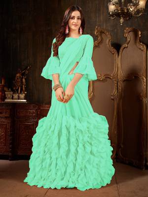 Add This Beautiful Designer Ruffled Saree To Your Wardrobe In Sea Green Color For The Upcoming Festive And Wedding Season. This Trendy Saree Is Fabricated On Georgette Paired With Art Silk And Georgette Fabricated Blouse. Its Trendy Pattern And Pretty Color Will EArn You Lots Of Compliments From Onlookers. 