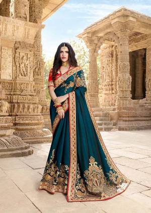 Here Is A Very Beautiful Rich And Elegant Looking Designer Saree In Prussian Blue Color Paired With Contrasting Red Colored Blouse. This Saree Is Fabricated On Silk Georgette Paired With Art Silk Fabricated Blouse. It Is Beautified With Attractive Embroidery Over The Pallu And Panel. 