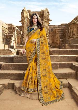 Catch All The Limelight At The Next Wedding You Attend Wearing This Heavy Designer Saree In Yellow Color Paired With Contrasting Prussian Blue Colored Blouse. This Saree Is Fabricated On Satin Silk Paired With Art Silk Fabricated Blouse. 