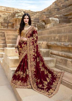 For A Royal Queen Look, Grab This Heavy Designer Saree In Maroon Color Paired With Beige Colored Blouse. This Saree Is Fabricated On Silk Georgette Paired With Art Silk Fabricated Blouse. It Is Beautified With Heavy Embroidery Giving It More Attractive Look. 