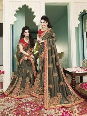 Add This Beautiful Shade To Your Wardrobe With This Heavy Designer Saree In olive Green Color Paired With Contrasting Red Colored Blouse. This Saree And Blouse aRe Rich Silk Based Beautified With Attractive Embroidery. Buy Now.