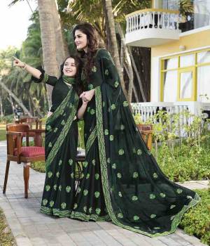 Get Ready For The Upcoming Festive Season With This Beautiful Designer Saree In Dark Green Color Paired With Dark Green Colored Blouse. This Saree Is Fabricated On Chiffon Paired With Art Silk Fabricated Blouse. It Is Beautified With Embroidered Lace Border And Butti.