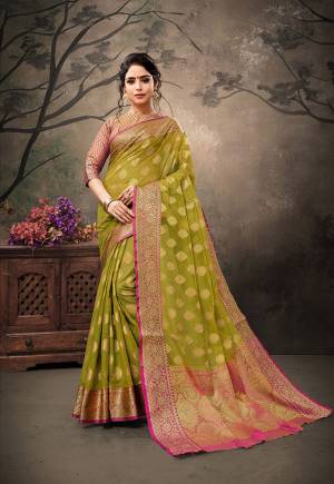 You Will Definitely Earn Lots Of Compliments Wearing This Designer Silk Based Saree In Olive Green Color Paired With Contrasting Pink Colored Blouse. This Saree And Blouse Are Fabricated On Banarasi Art Silk Which Gives Rich Look To Your Personality. 