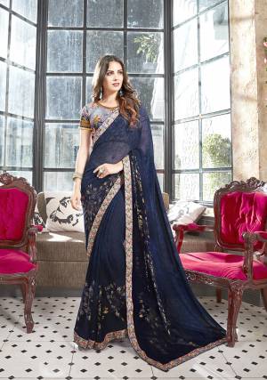 Enhance Your Personality Wearing This Lovely Floral Printed Saree In Navy Blue Color Paired With Contrasting Grey Colored Blouse. This Saree Is Georgette Based Paired With Art Silk Fabricated Blouse. It Is Beautified With Foil And Floral Prints. 