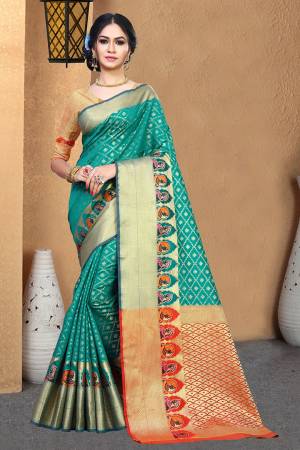 Celebrate This Festive Season With Beauty And Comfort Wearing This Designer Silk Based Saree In Sea Green Color Paired With Contrasting Orange Colored Blouse. This Saree And Blouse Are Fabricated On Patola Art Silk Beautified With Weave. 
