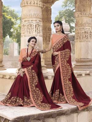 For A Royal Look, Grab This Heavy Designer Saree In Maroon Color Paired with Contrasting Dark Peach Colored Blouse. This Saree Is Georgette Based Paired With Art Silk Fabricated Blouse. Its Rich Color Pallete And Pattern Will Earn You Lots Of Compliments From Onlookers. 