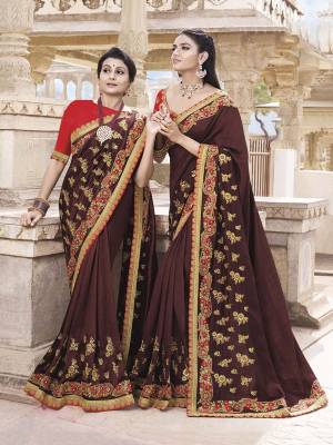 For A Royal Look, Grab This Heavy Designer Saree In Maroon Color Paired with Contrasting Red Colored Blouse. This Saree Is Silk Based Paired With Art Silk Fabricated Blouse. Its Rich Color Pallete And Pattern Will Earn You Lots Of Compliments From Onlookers. 