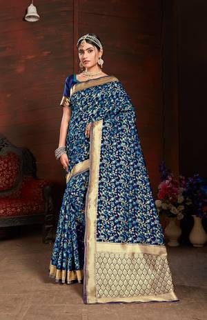 Add This Very Pretty Silk Based Saree To Your Wardrobe In Blue With A Base OF Navy Blue Color. This Saree Is Fabricated On Banarasi Art Silk Paired With Art Silk Fabricated Blouse. It Is Beautified With Small Floral Weave All Over It. 