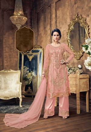 Look Pretty In This Heavy Designer Suit In All Over Pink Color. This Heavy Top Is Net Based Paired With Satin Silk Embroidered Bottom And Net Fabricated Dupatta. To Give More Heavy Look It Is Beautified With Tone To Tone Colored Pearl Work. Buy This Pretty Suit Now.