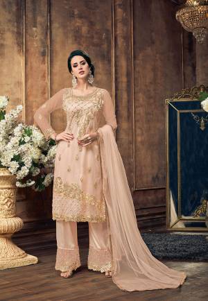 Flaunt Your Rich And Elegant Taste With This Designer Straight Suit In Pastel Peach Color. This Pretty Suit Is Net Based Paired With Embroidered Satin Based bottom and Net Fabricated Dupatta. Its Top Is Beautified With Heavy Embroidery And Same Colored Pearl Work.