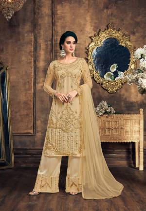Flaunt Your Rich And Elegant Taste With This Designer Straight Suit In Beige Color. This Pretty Suit Is Net Based Paired With Embroidered Satin Based bottom and Net Fabricated Dupatta. Its Top Is Beautified With Heavy Embroidery And Same Colored Pearl Work.