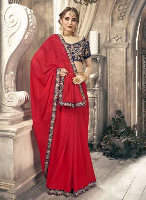 Bright And Visually Appealing Color Is Here With This Pretty Designer Saree In Red Color Paired With Contrasting Navy Blue Colored Blouse. This Saree Is Fabricated On Chiffon Paired With Art Silk Fabricated Heavy Embroidered Blouse.
