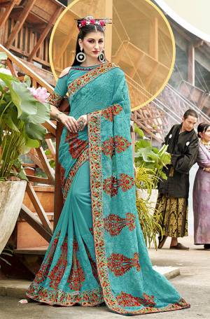 Get Ready For The Upcoming Festive And Wedding Season With This Heavy Designer Saree In Turquoise Blue Color Paired With Turquoise Blue Colored Blouse. It Is Beautified With Heavy Embroidery All Over Which Will earn You Lots of Compliments From Onlookers. 