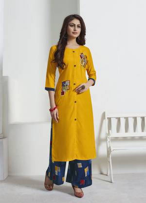 Celebrate This Festive Season With Beauty And Comfort Wearing This Readymade Pair Or Kurti And Pant. Its Kurti Is In Yellow Color Paired With Contrasting Blue Colored Bottom. This Pretty Pair Is Rayon Based Beautified With Prints And Thread Work. 