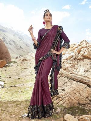 A Must Have Shade In Every Womens Wardrobe Is Here With This Designer Saree In Wine Color Paired With Wine Colored Blouse. This Saree Is Fabricated On Lycra Paired With Art Silk Fabricated Blouse. It Is Beautified With Frill And Lace Border. 