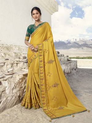 Celebrate This Festive Wearing This Very Pretty And Elegant Looking Designer Saree In Yellow Color Paired With Contrasting Pine Green Colored Blouse. This Saree Is Soft Silk Based paired With Art Silk Fabricated Blouse. 