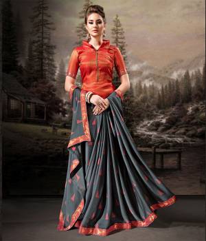 Rich And Elegant Looking Saree Is Here In Dark Grey Color Paired With Contrasting Orange Colored Blouse. This Saree Is Fabricated On Chiffon Paired With Art Silk Fabricated Blouse. Its Fabric Is Light Weight, Durable And Easy To Carry All Day Long. 