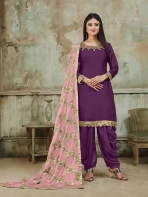 Grab This Very Beautiful And Attractive Looking Designer Suit In Purple Color Paired With Light Pink Colored Dupatta. Its Top Is Fabricated On Satin Beautified With Embroidery Over Neckline, Paired With Santoon Fabricated Bottom And With Heavy Gota Work Chinon Fabricated Dupatta. The Main Highlight Of This Beautiful Suit Is Its Heavy Dupatta Which Has Gota Work. Buy This Suit Now.