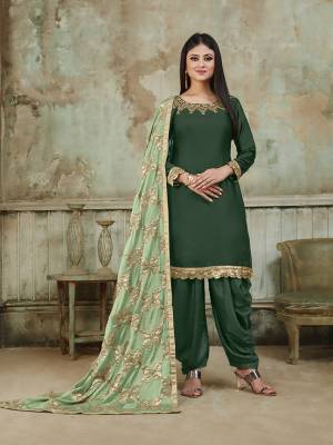 Grab This Very Beautiful And Attractive Looking Designer Suit In Dark Green Color Paired With Pastel Green Colored Dupatta. Its Top Is Fabricated On Satin Beautified With Embroidery Over Neckline, Paired With Santoon Fabricated Bottom And With Heavy Gota Work Chinon Fabricated Dupatta. The Main Highlight Of This Beautiful Suit Is Its Heavy Dupatta Which Has Gota Work. Buy This Suit Now.