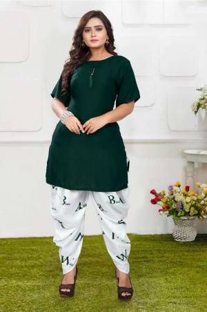 Grab This Pretty Pair Of Readymade Kurti And Dhoti In Pine Green And White Color. This Kurti Is Fabricated On Rayon Slub Paired With Crepe Fabricated Digital Printed Dhoti. It Is Available In All Regular Sizes And Ensures superb Comfort All Day Long. Buy Now.