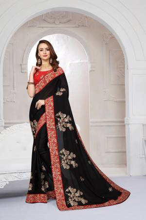 Get Ready For The Upcoming Festive And Wedding Season With This Heavy Designer Saree In Black Color Paired With Red Colored Blouse. This Saree Is Fabricated On Chiffon Satin Paired With Art Silk Fabricated Blouse. It Is Beautified With Attractive Embroidery With Heavy embroidered Lace Border. 